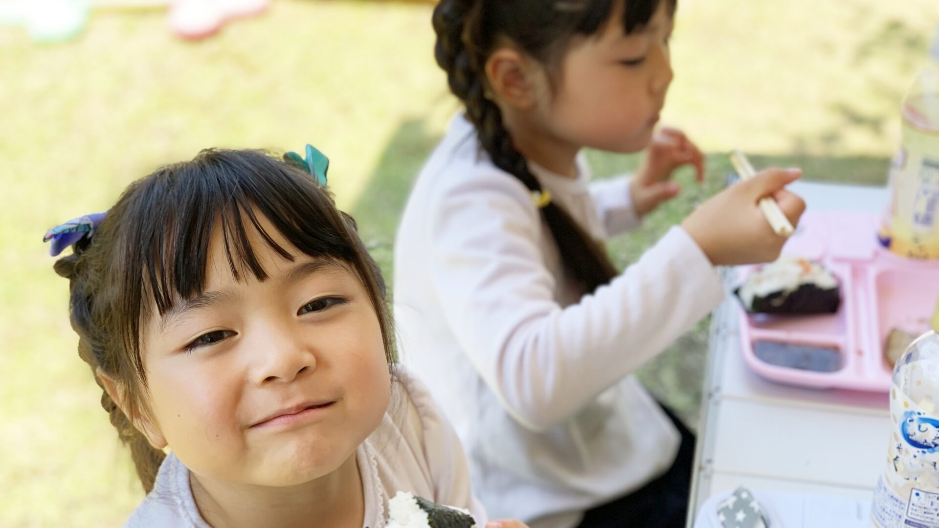 女の子がお庭でご飯を食べている